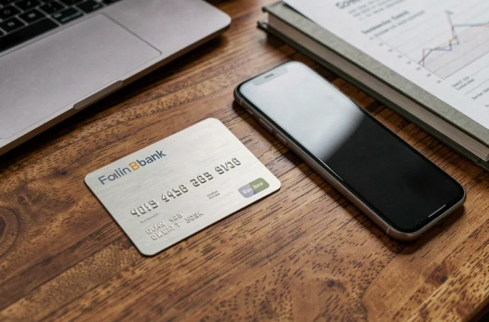 Carte bancaire premium et smartphone sur bureau en chêne représentant l'identité visuelle de Boursobank filiale de Société Générale