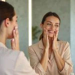 Femme appliquant un serum visage dans une salle de bain élégante
